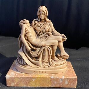 Sculpted Pieta (pity) on a marble base. Original artist Michael Angelo